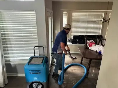 Extraction hose laid across a living room floor next to a dehumidifier